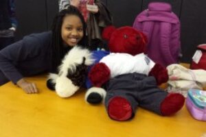 Young girl smiling with stuffed animals